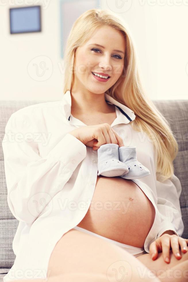 glückliche schwangere Frau, die auf dem Sofa ruht foto