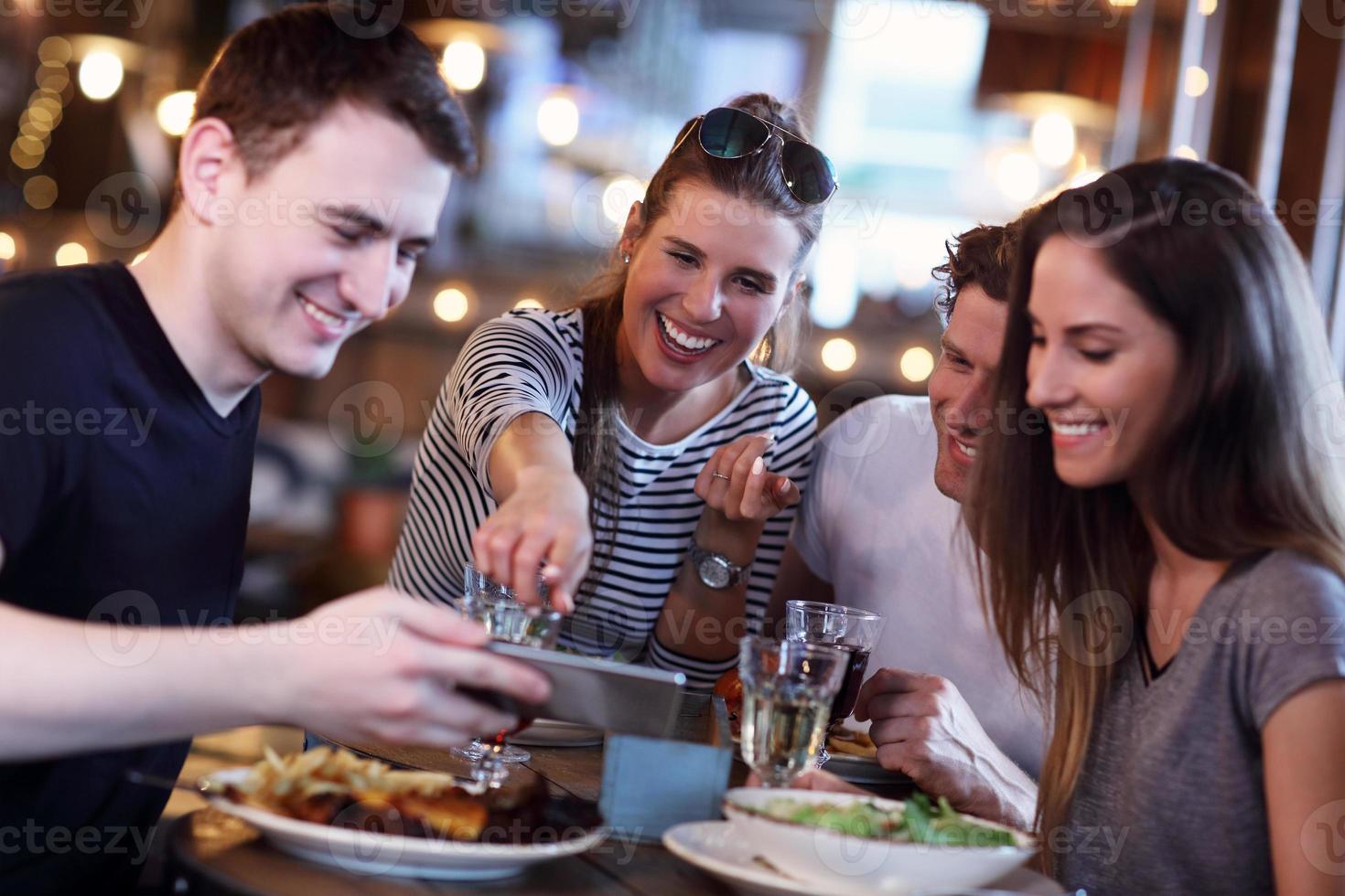 gruppe von freunden, die mahlzeit im restaurant genießen foto