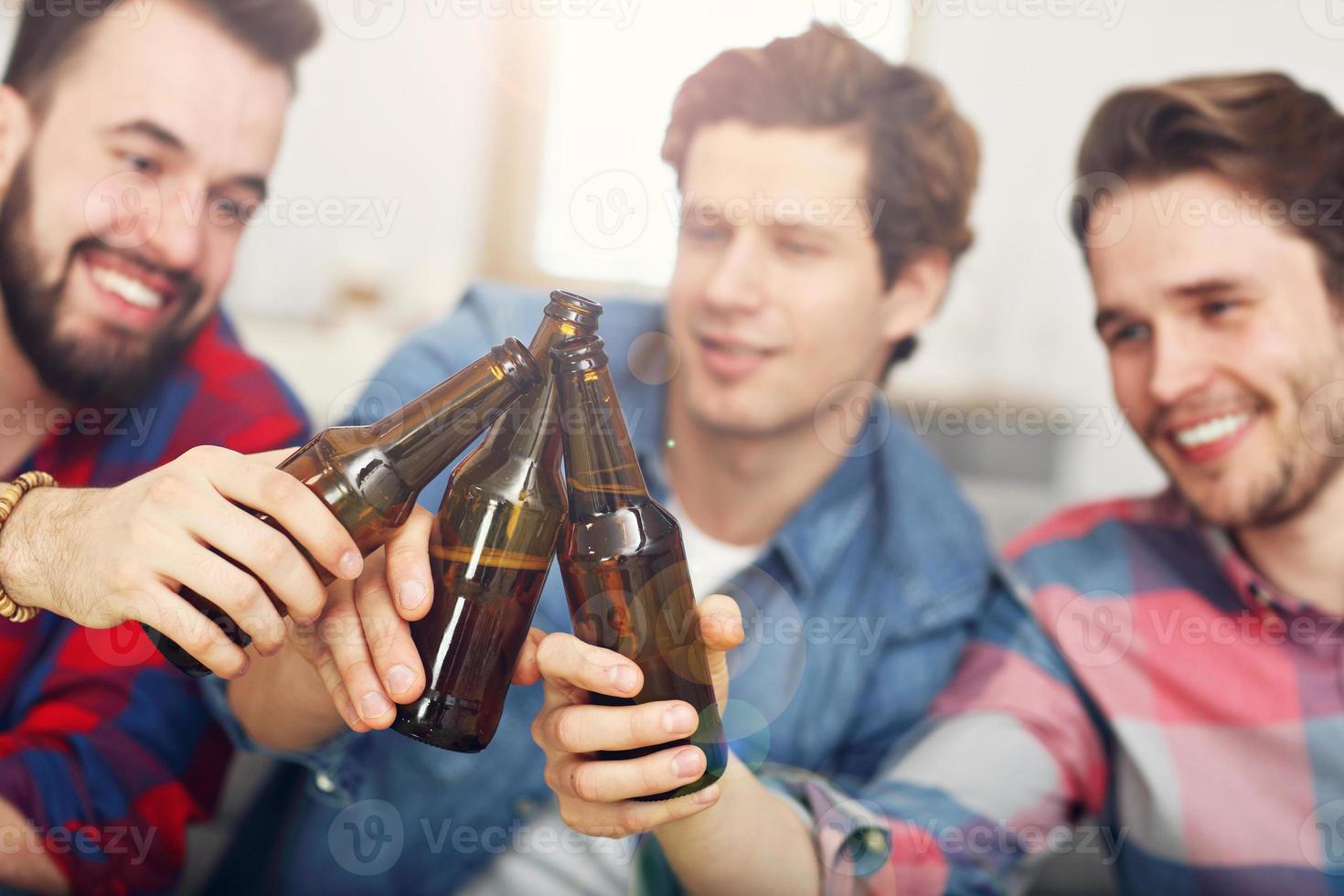 glückliche männliche freunde jubeln und sehen sport im fernsehen foto