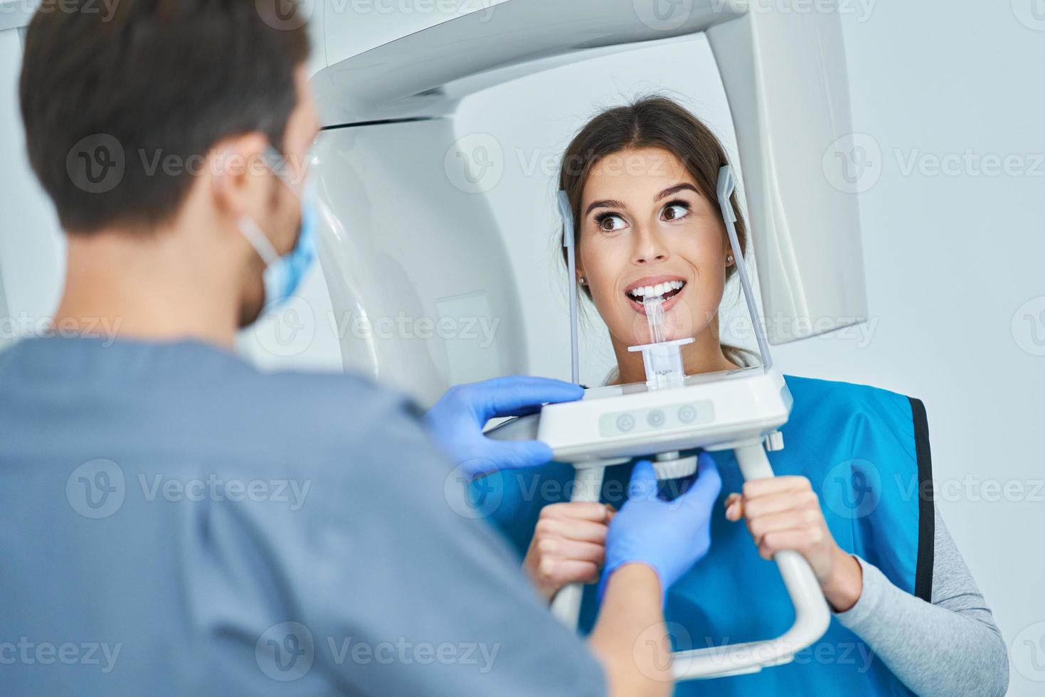 Zahnarzt, der eine digitale Panorama-Röntgenaufnahme der Zähne eines Patienten macht foto