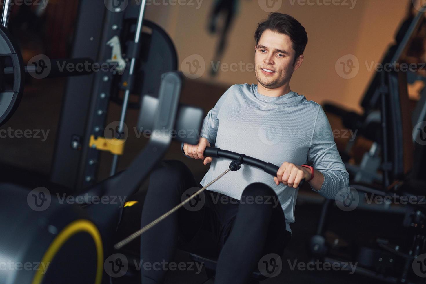 erwachsener mann, der in einem fitnessstudio trainiert foto