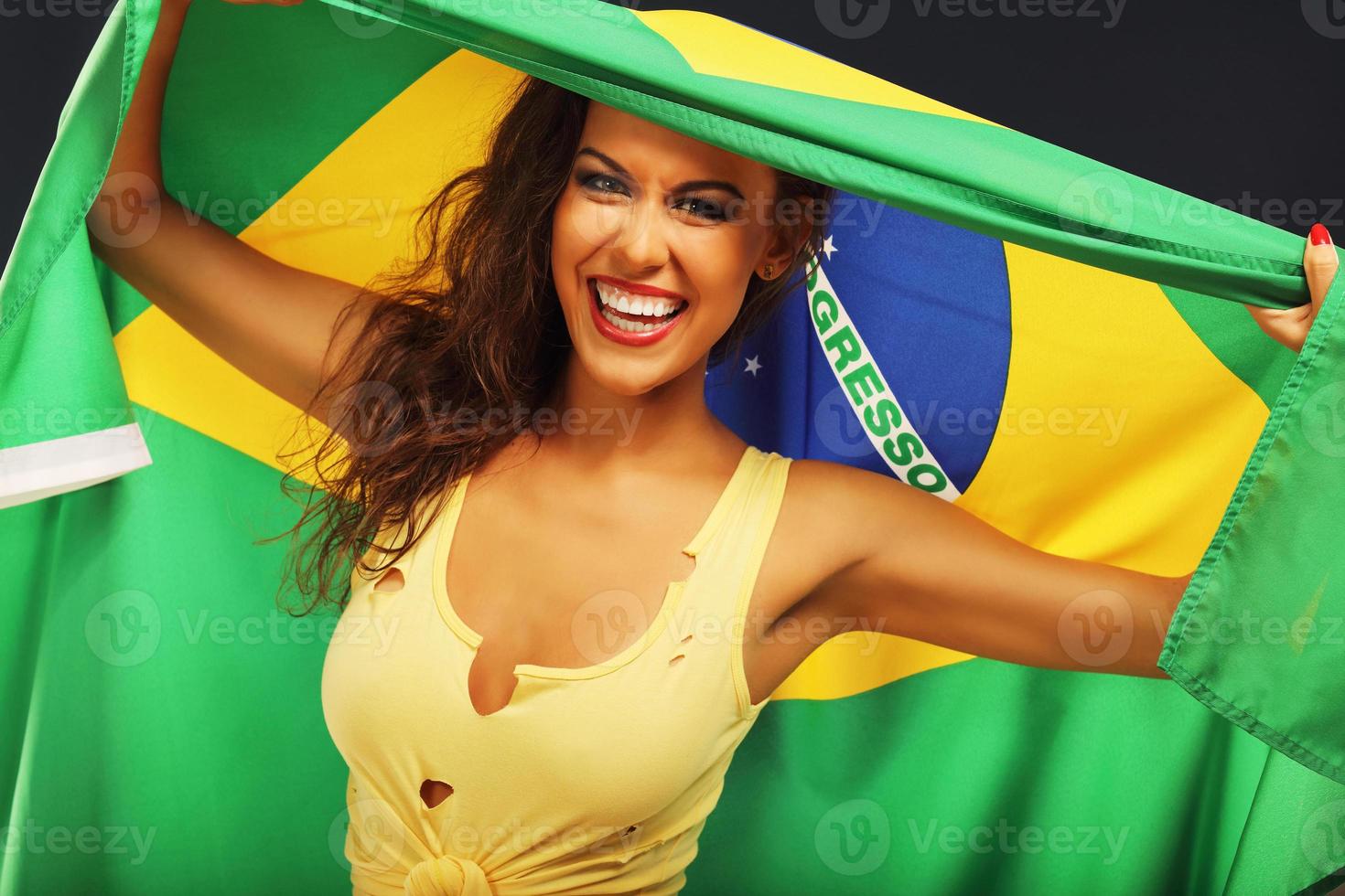 glücklicher brasilianischer fan, der mit flagge jubelt foto