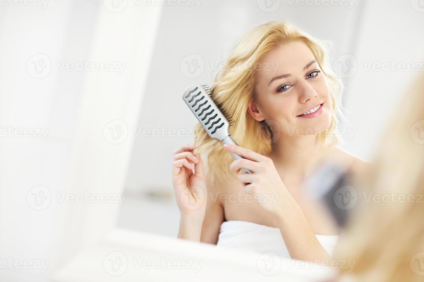 junge frau, die haare bürstet foto