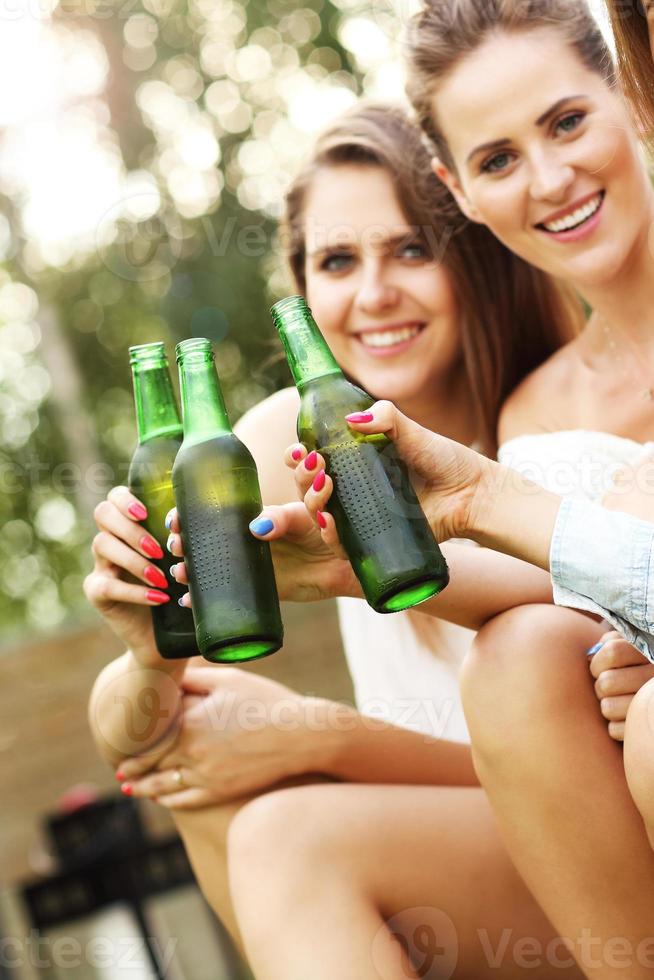 glückliche gruppe von freunden, die draußen bier trinken foto