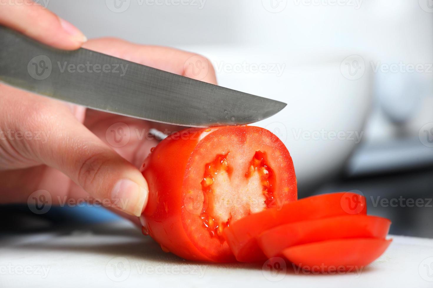 Person, die Tomaten schneidet foto