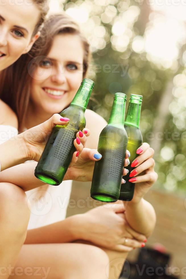 glückliche gruppe von freunden, die draußen bier trinken foto