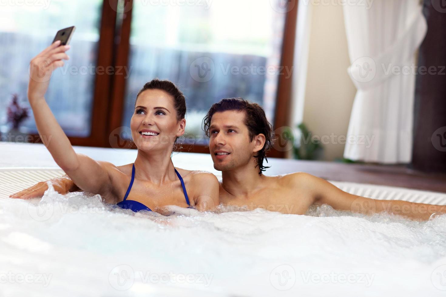 glückliches Paar genießt Whirlpool im Spa des Hotels foto