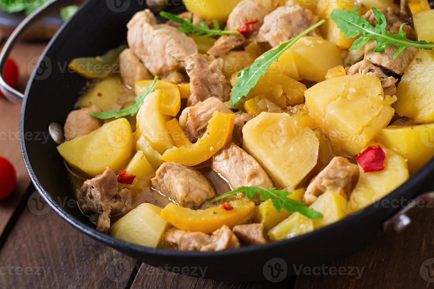 Geschmorte Kartoffeln mit Fleisch und Gemüse in einer Bratpfanne auf Holzhintergrund foto