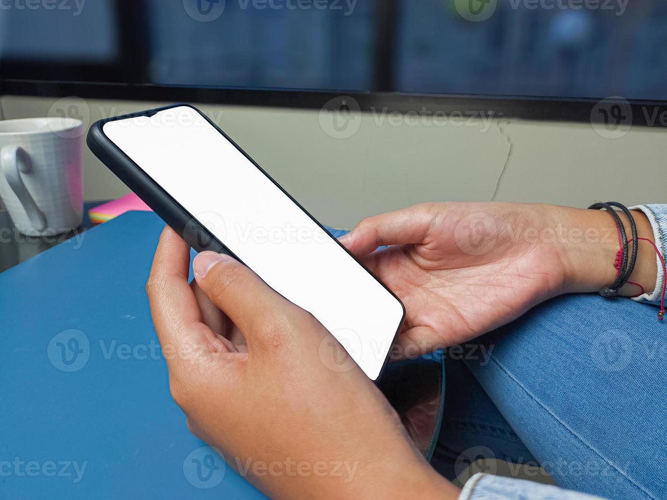nahaufnahme einer frauenhand, die einen weißen smartphonebildschirm hält, ist leer. mockup. foto