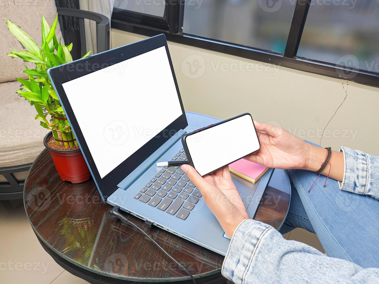 computer, leerer bildschirm telefonmodellbild mit weißem hintergrund für werbung, frauenhand mit laptop und handy auf dem tisch im cafe.mockup foto