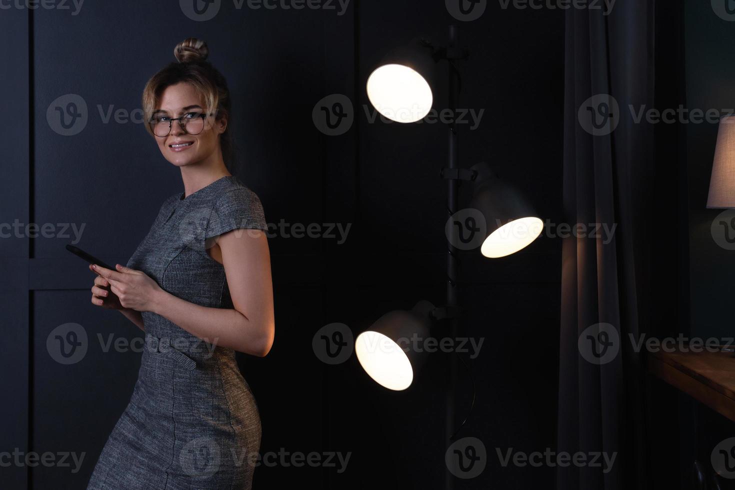Geschäftsfrau benutzt Smartphone während der Nachtarbeit foto