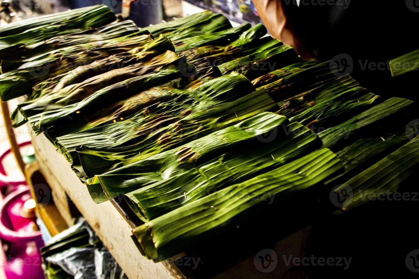 Otak - Otak ist ein Gericht aus gehacktem Makrelenfischfleisch, das in Bananenblätter gewickelt, gebacken und mit scharfer und saurer Soße serviert wird. Otak-Otak ist ein traditioneller Fischkuchen aus Indonesien foto