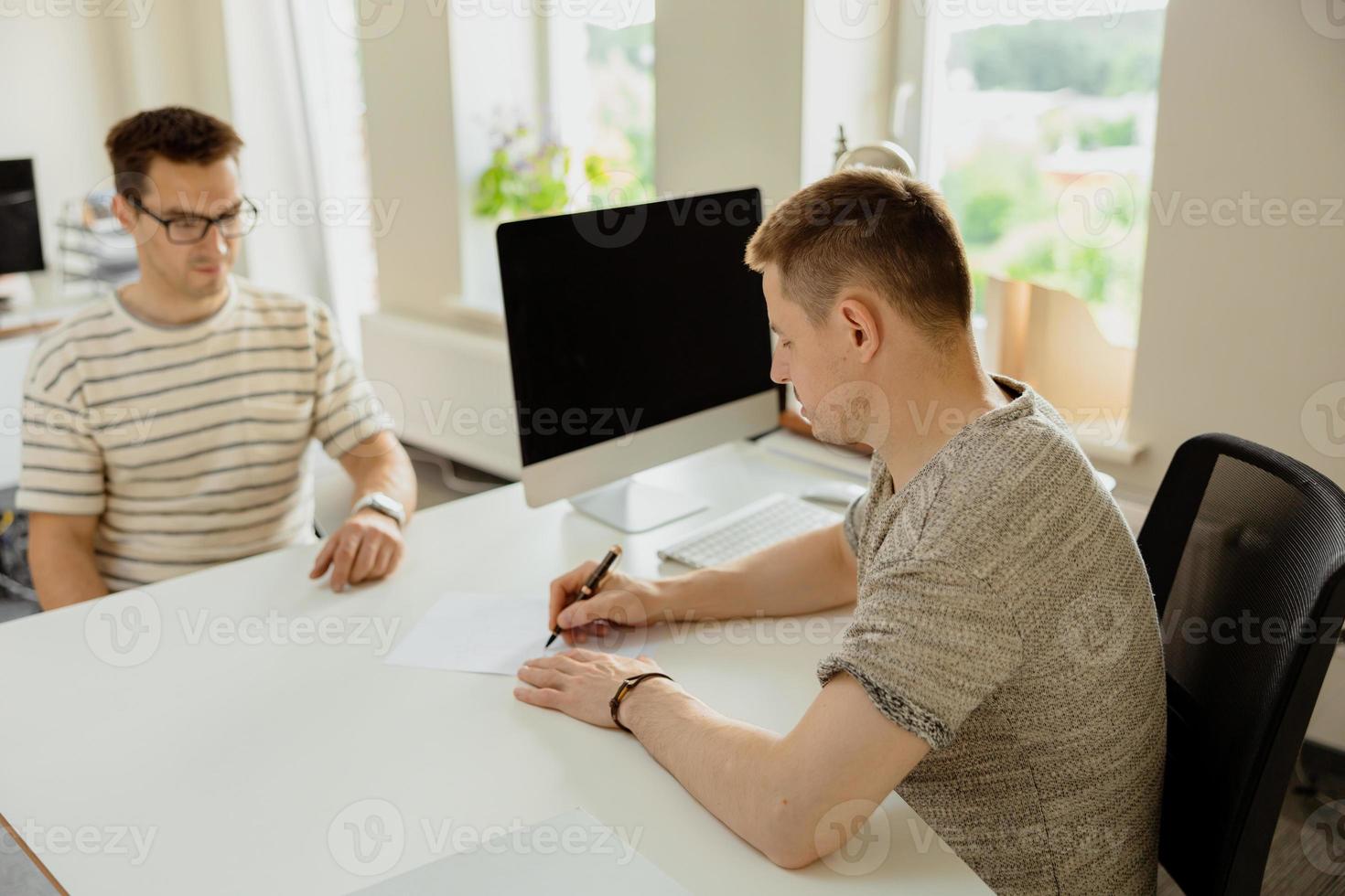 seriöser professioneller mann, der kunden im büro berät. zwei männer treffen sich, führen geschäftsgespräche. versicherer berät, manager macht angebot. Mentor Lehrpraktikant Vorstellungsgespräch. foto