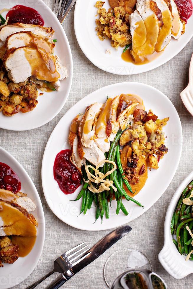 festlicher Thanksgiving-Esstisch mit Tellern mit Essen foto