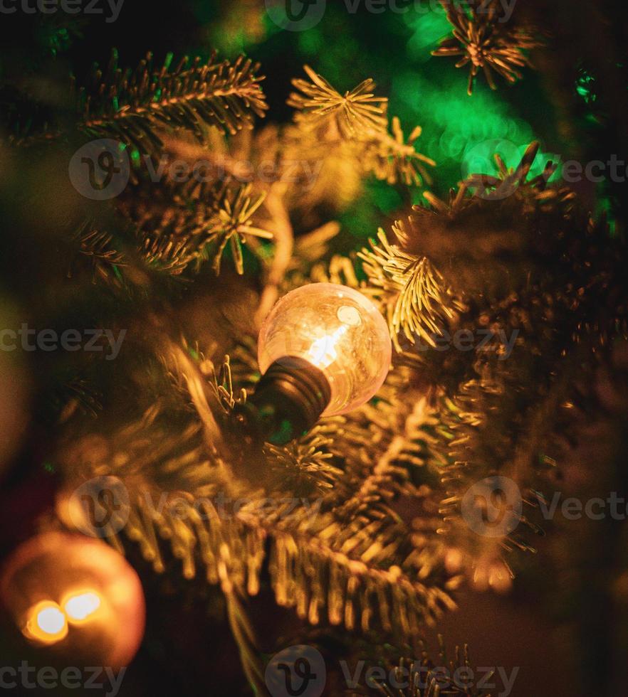 gelbes weihnachtslicht, das in einem weihnachtsbaum hängt foto