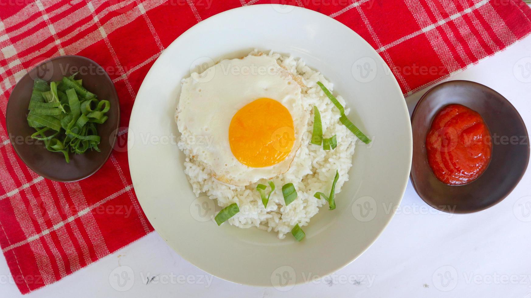 gebratener Eierreis. Frühstück Spiegelei Sonnenseite Reis auf einem Teller, isoliert auf weißem Hintergrund foto