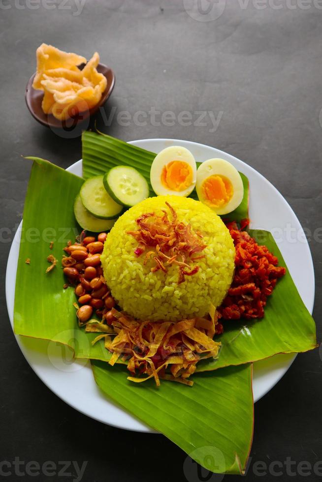 nasi kuning oder gelber reis oder kurkumareis ist ein traditionelles essen aus asien, hergestellter reis gekocht mit kurkuma, kokosmilch r foto