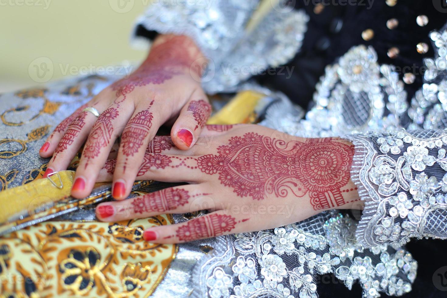 Henna-Tattoo wird auf die Hand einer Frau aufgetragen. foto