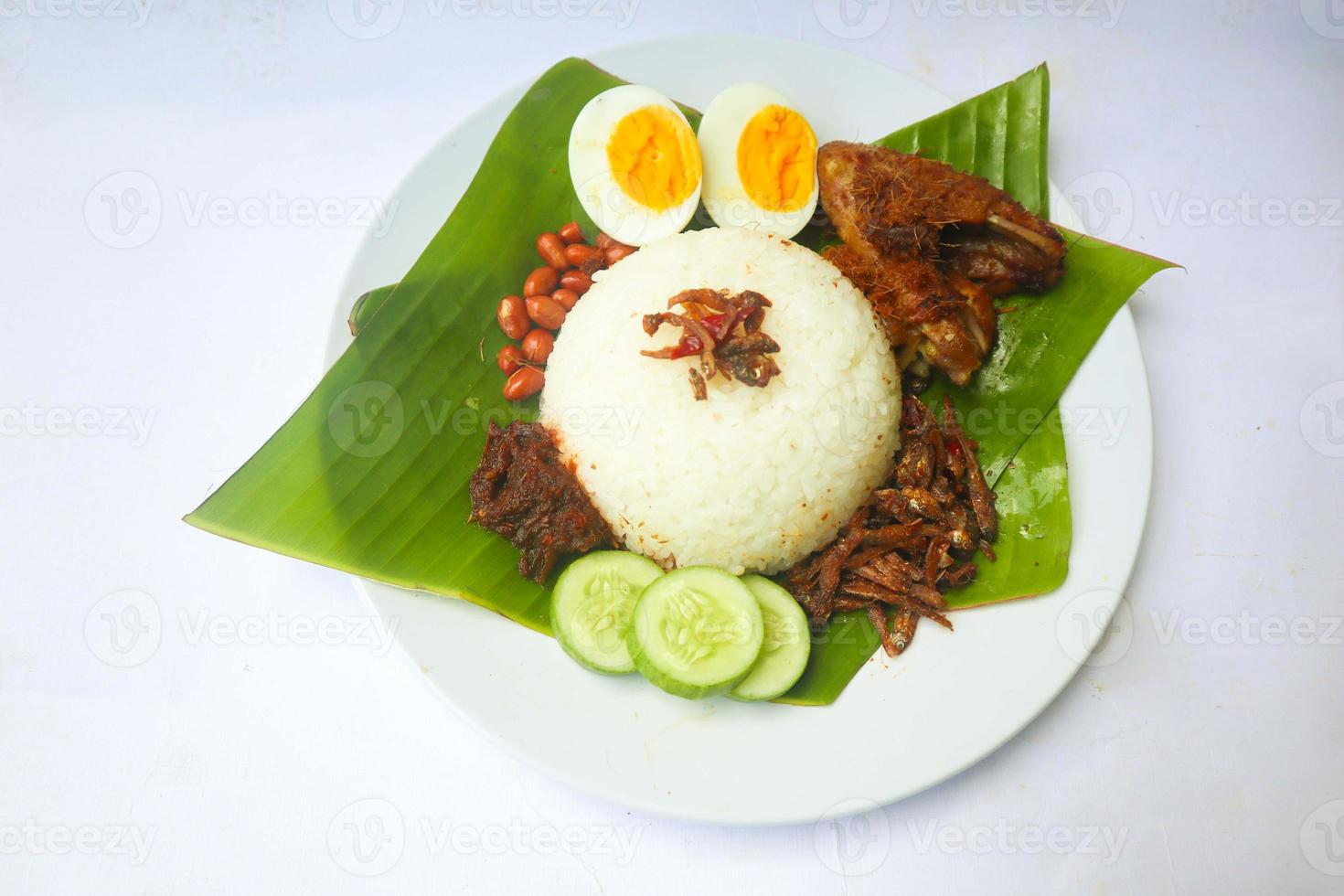 Nasi Lemak ist ein traditionelles malaiisches Gericht aus gekochten Eiern, Bohnen, Sardellen, Chilisauce und Gurken. isoliert auf weißem Hintergrund foto