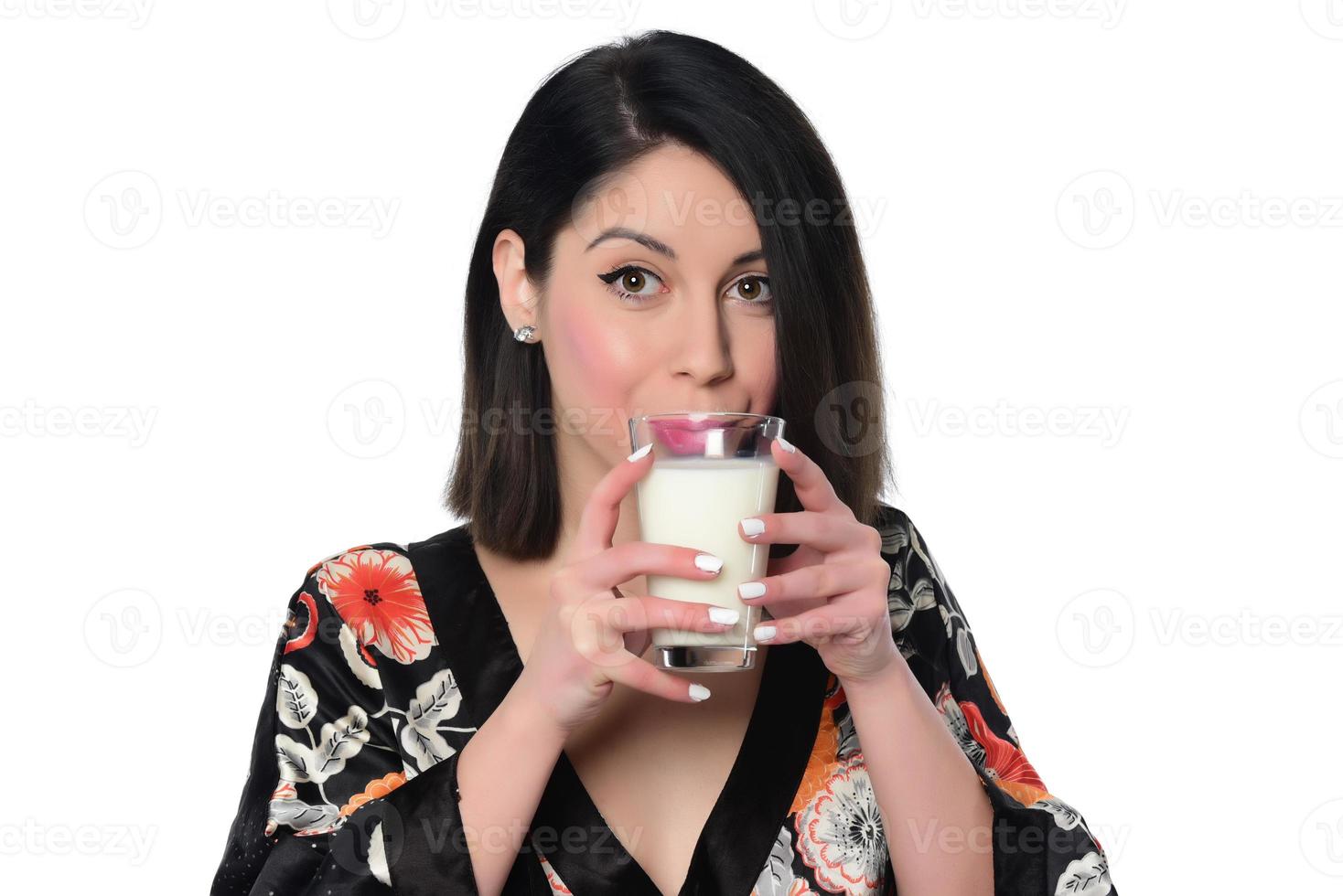 Frau, die Milch hält und trinkt. foto