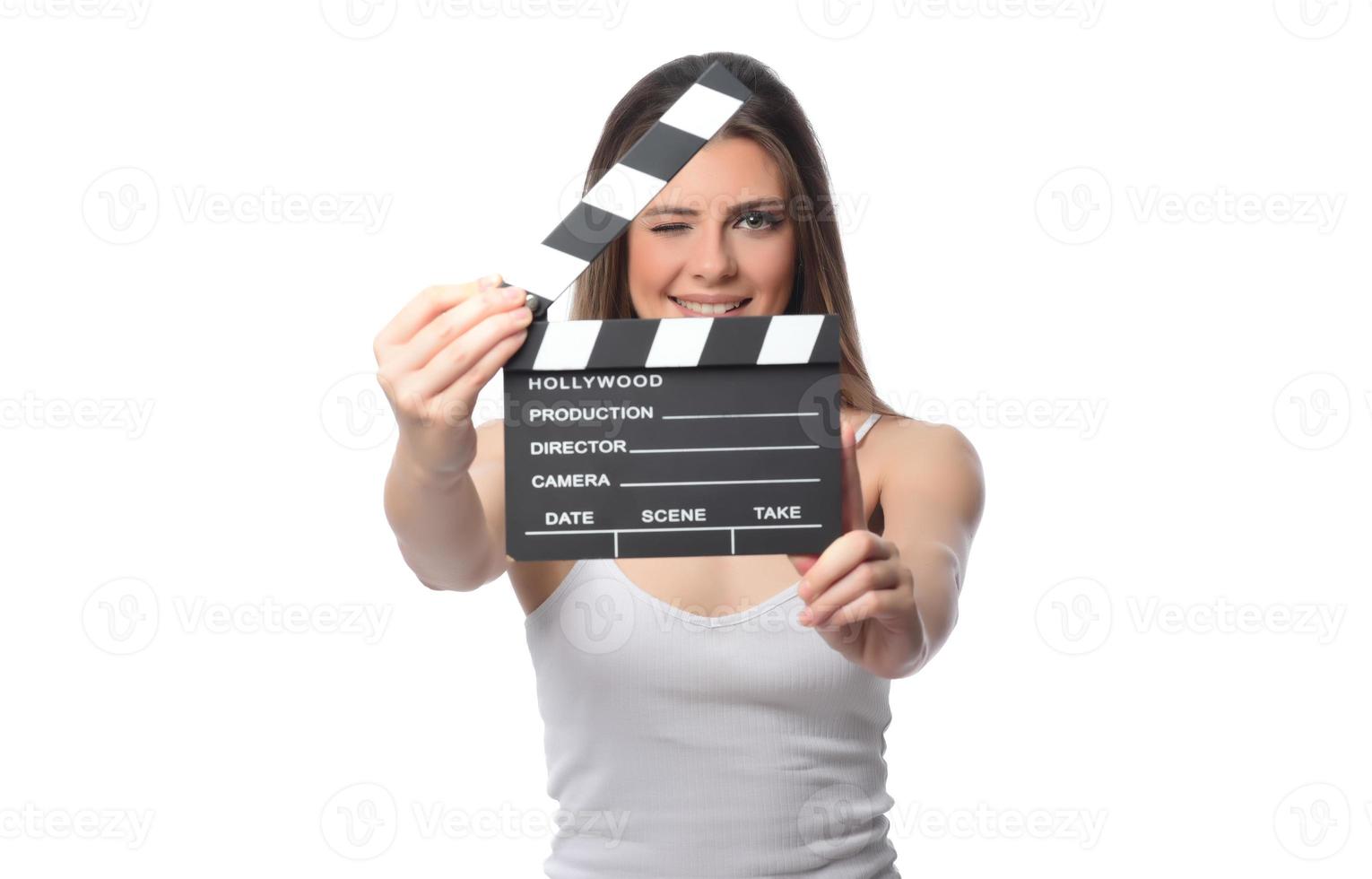 schöne junge Frau mit Kinoklöppel posiert im Studio. Filmkonzept. isoliert foto
