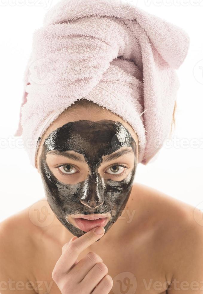 schwarze Gesichtsmaske. schönes Mädchen, das schwarze Maske ablegt. Beauty-Konzept foto