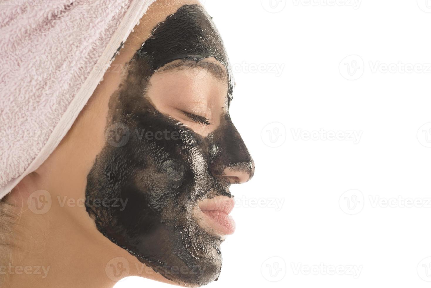 schwarze Gesichtsmaske. schönes Mädchen mit schwarzer Kosmetikmaske im Gesicht. Beauty-Konzept foto