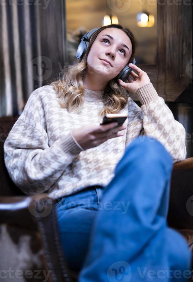 schöne kaukasische frau, die musik auf ihren drahtlosen kopfhörern hört foto