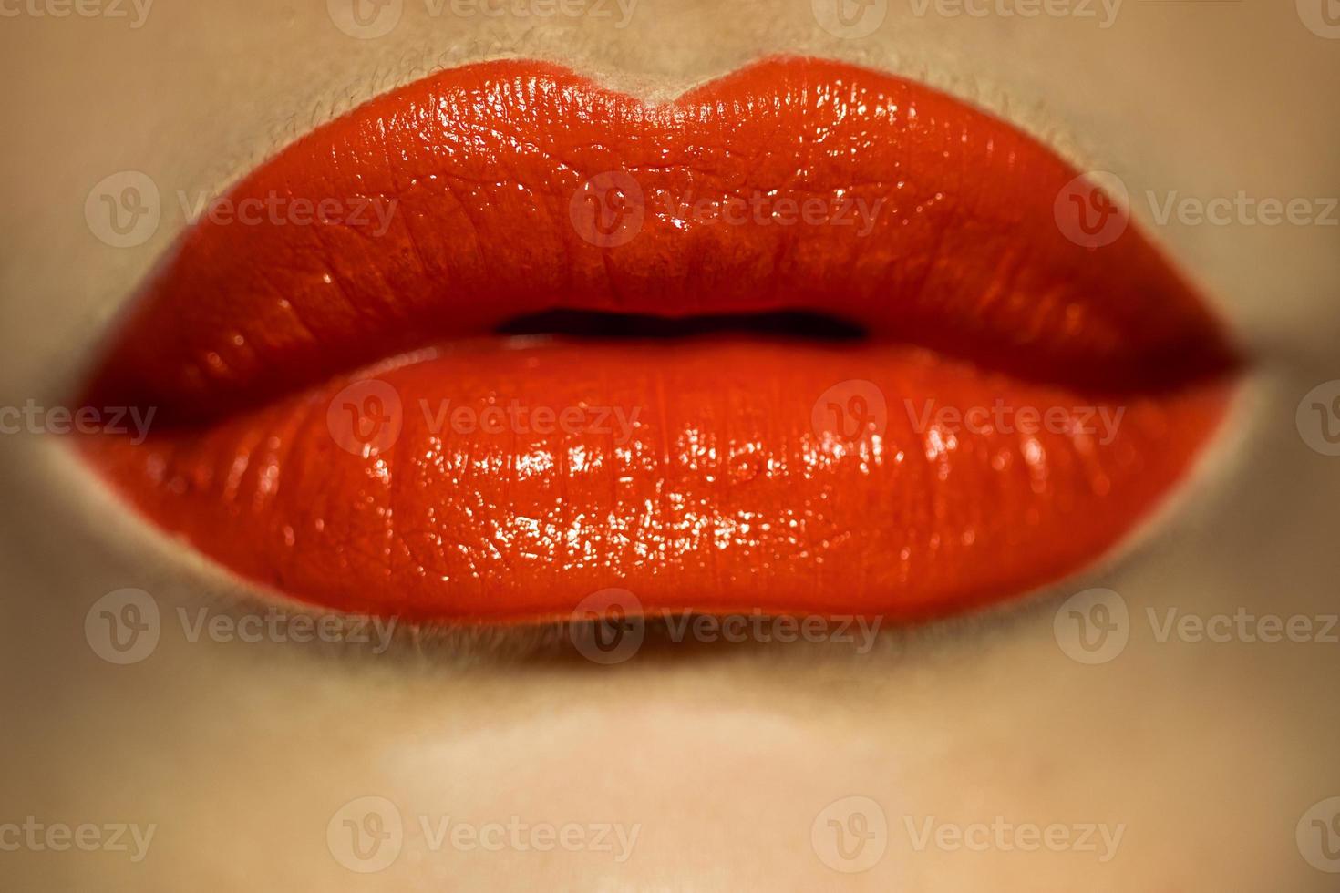 Makrobild der weiblichen Lippen mit rotem Lippenstift foto