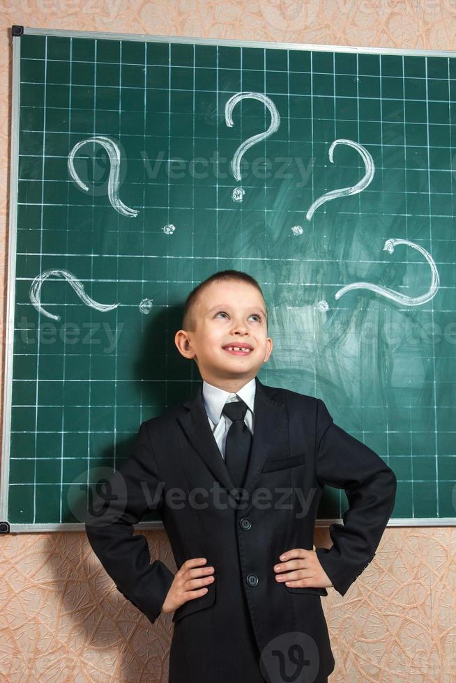 Junge in der Nähe der grünen Tafel foto