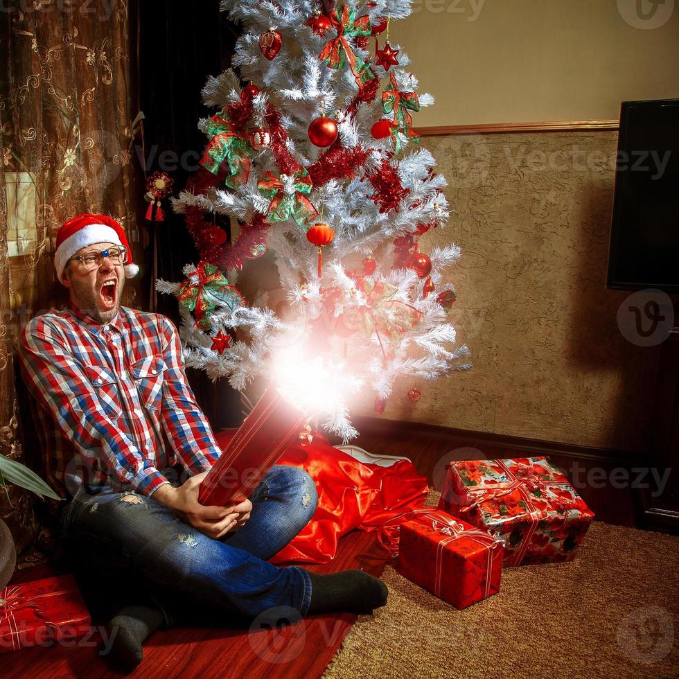 Nerd schreit, als er sein Weihnachtsgeschenk öffnet foto