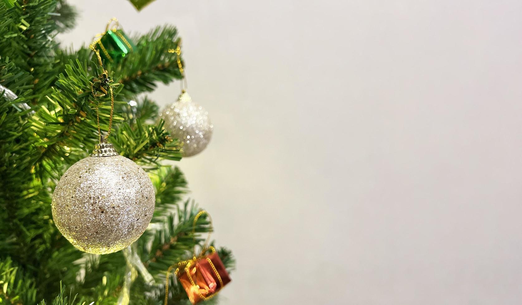 geschmückter Weihnachtsbaum mit bunten Geschenkbox und Glocke isoliert auf weißem Hintergrund foto