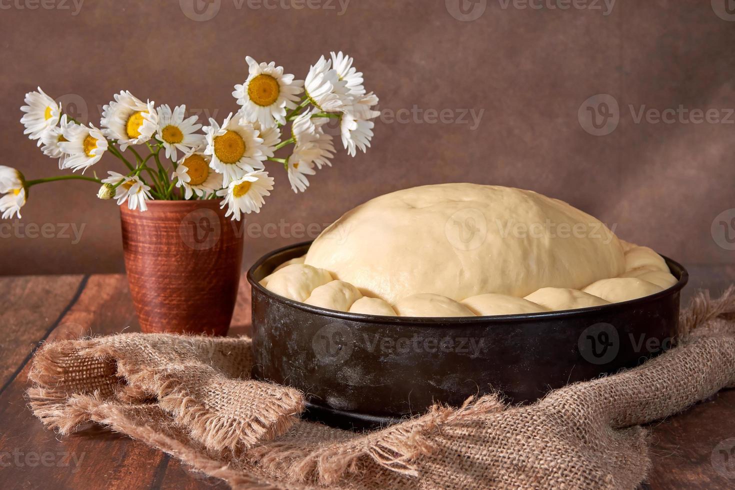 Teig für einen festlichen Kuchen auf einem Holztisch. Zubereitung des Teigs für das Hochzeitsbrot foto