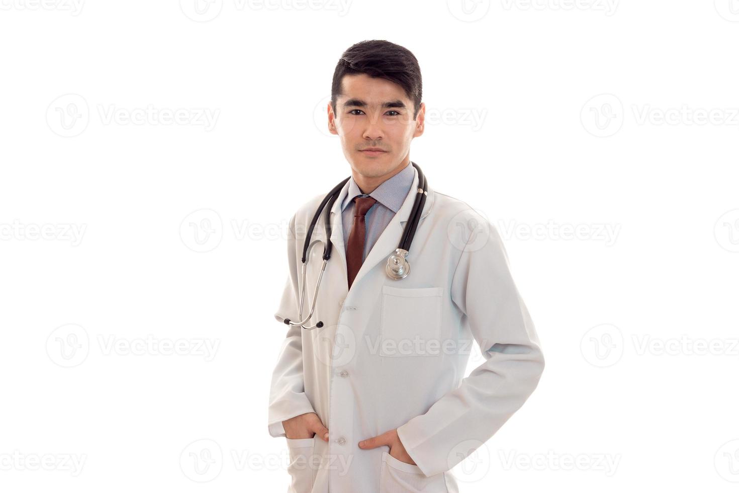schöne elegante Ärztin in Uniform mit Stethoskop posiert und schaut in die Kamera isoliert auf weißem Hintergrund foto