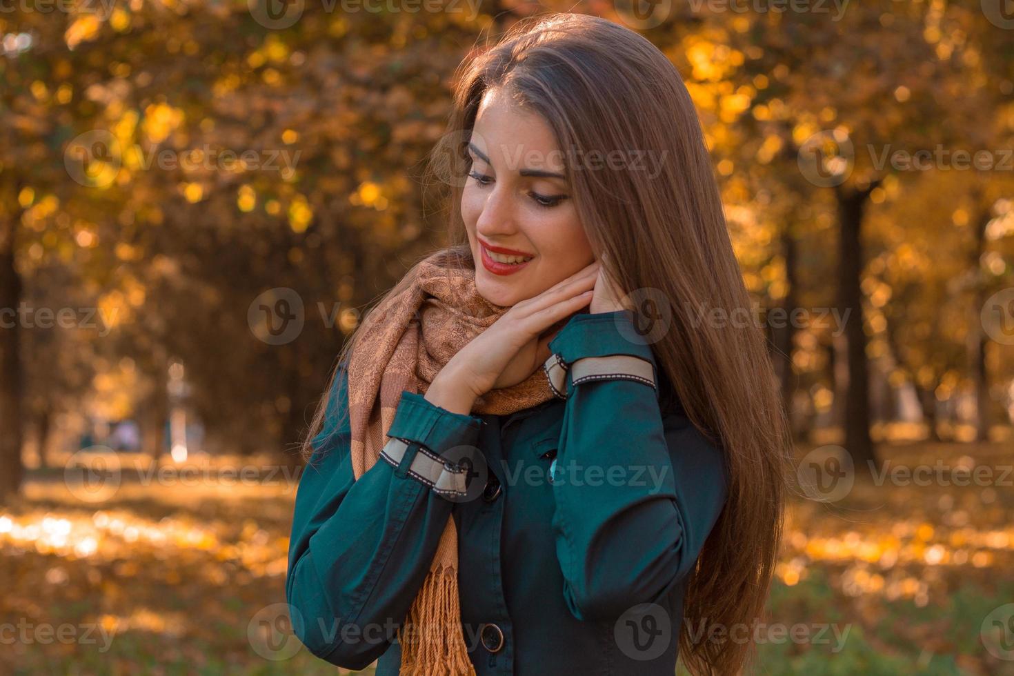 süßes Mädchen ist es wert, sich im Park seitwärts zu drehen und hält die Hände in der Nähe des Gesichts foto