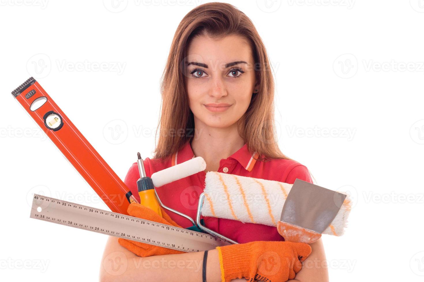Ein junges Mädchen hält eine Vielzahl von Werkzeugen für die Reparatur von Nahaufnahmen isoliert auf weißem Hintergrund foto