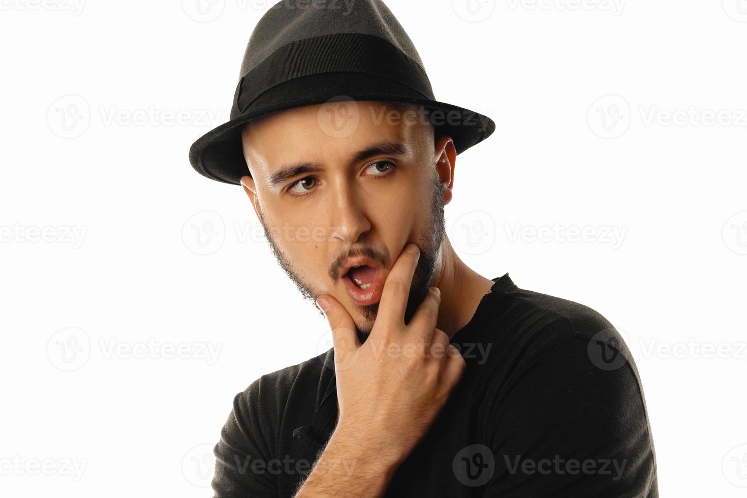 Porträt eines gutaussehenden unrasierten Machos mit Hut, der mit offenem Mund wegschaut foto