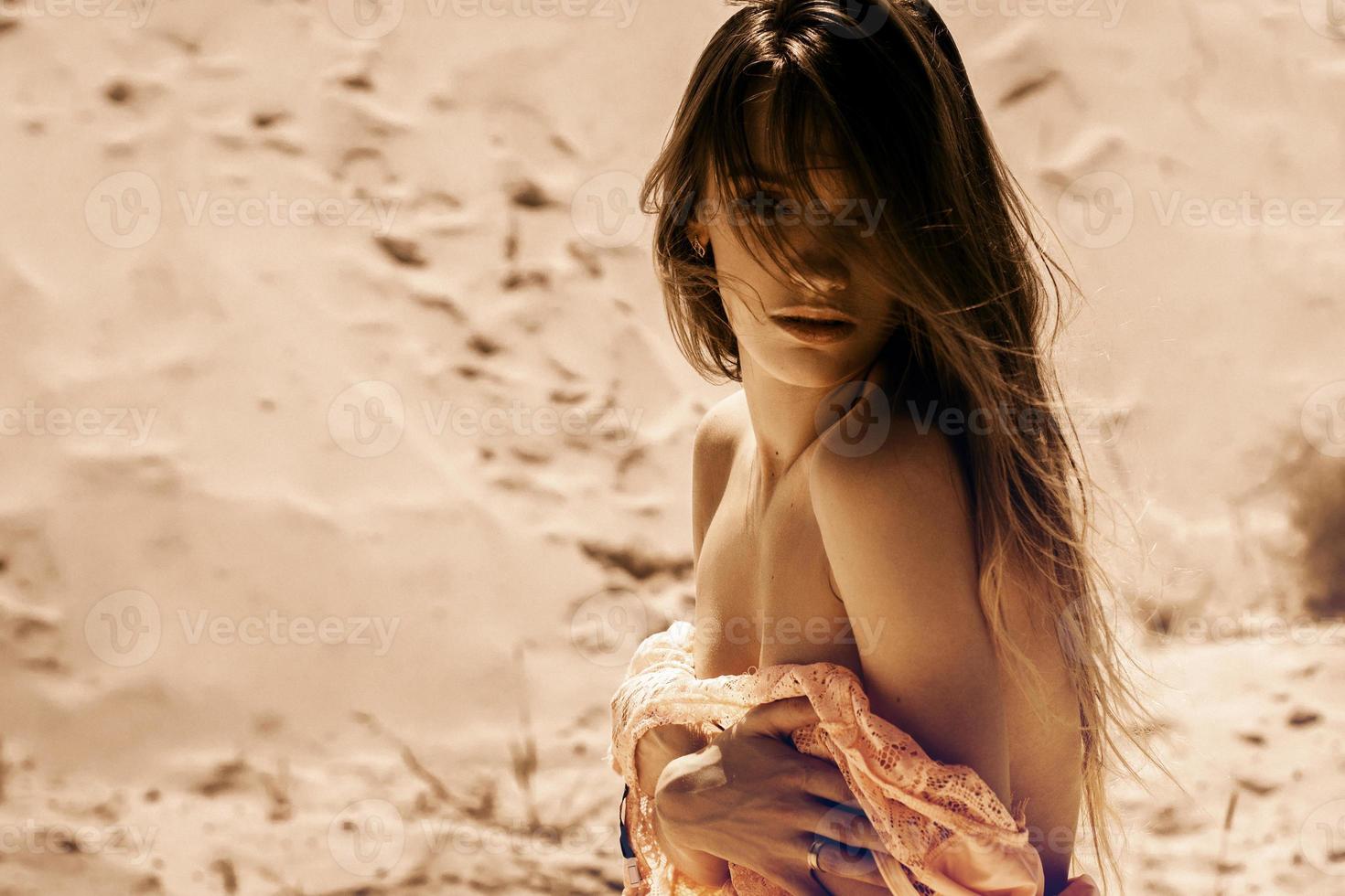 junge sexy dame zieht ein kleid in der wüste aus foto