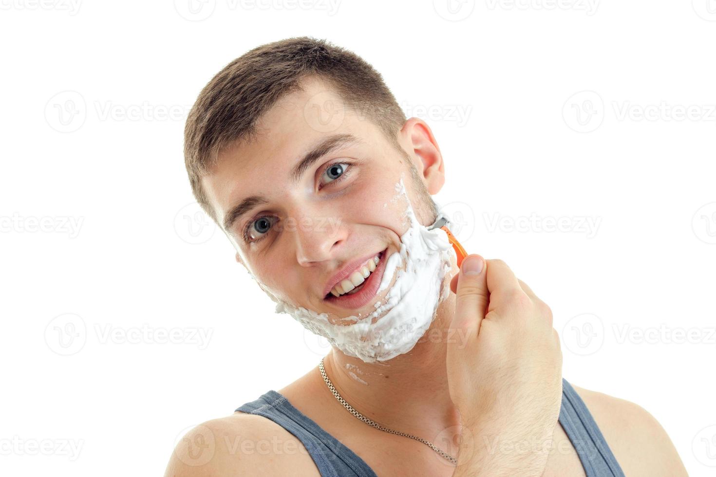 Porträt eines charmanten, fröhlichen Mannes mit Bart, Rasiermesser und Schaum isoliert auf weißem Hintergrund foto