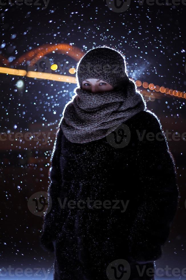 Silhouette eines Mannes auf dem Hintergrund des fallenden Schnees im Winter foto