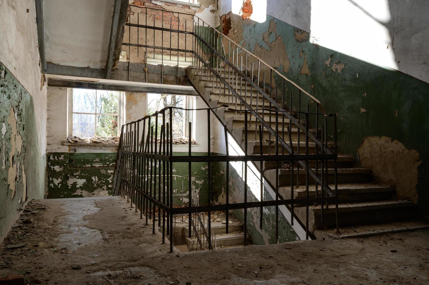 Treppe in einem verlassenen Haus, ein zerstörtes Industriegebäude, ein Haus mit zerbrochenen Fenstern. foto
