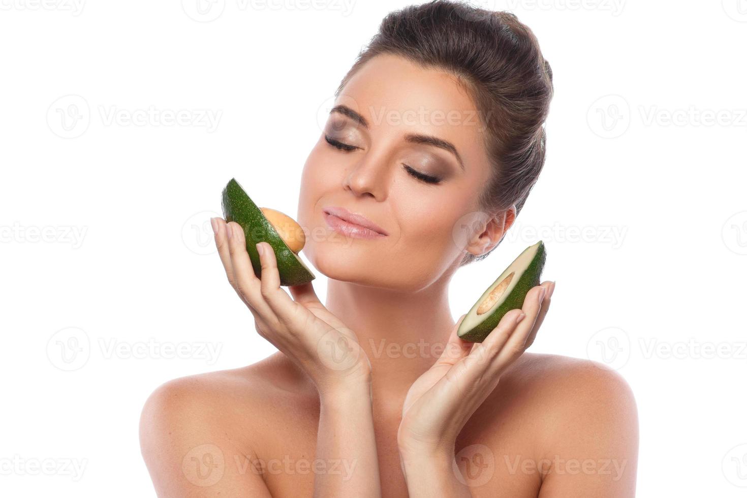 schöne Frau mit Avocado-Frucht auf weißem Hintergrund foto