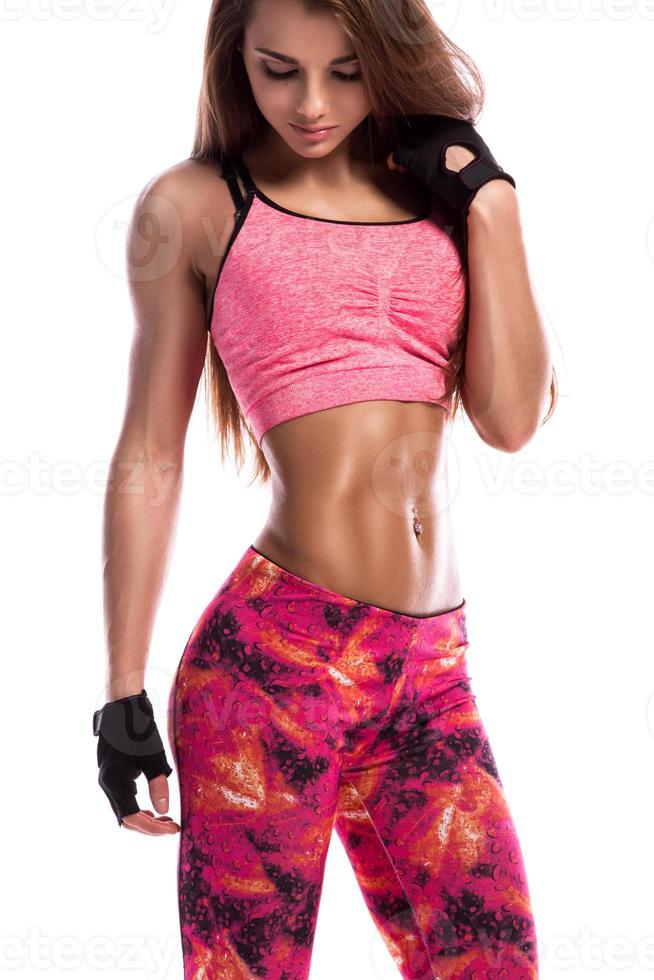 Schönes Fitness-Mädchen mit rosafarbenem Outfit im Studio foto