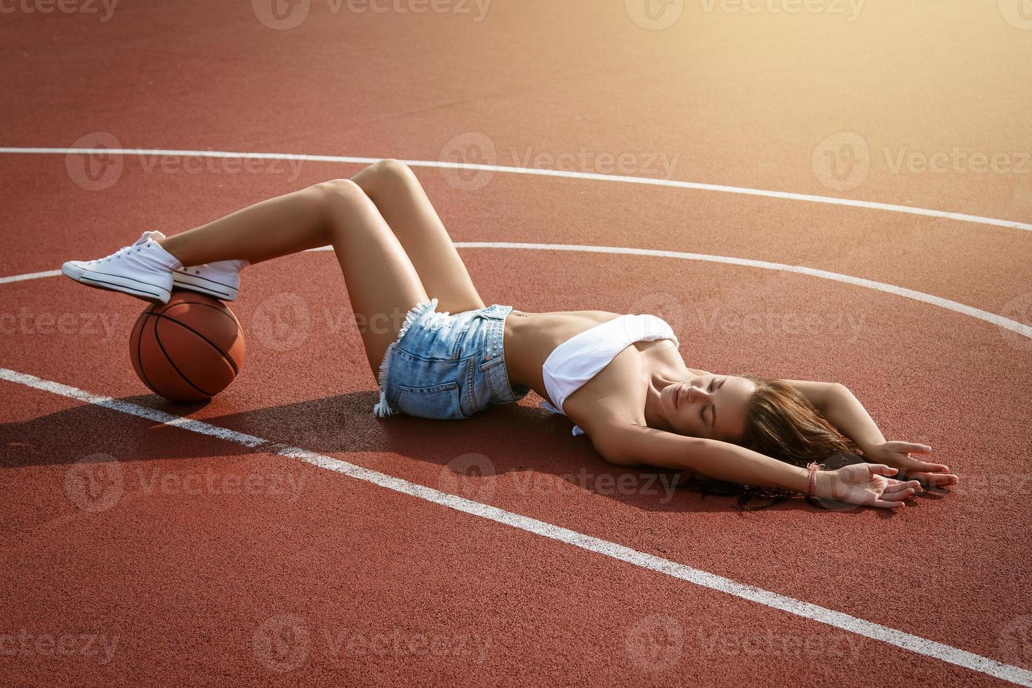 junge sexy Frau mit auf einem Basketballspielplatz foto