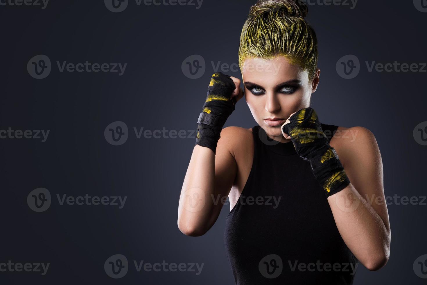Frau MMA-Kämpferin mit gelben Haaren im Studio foto