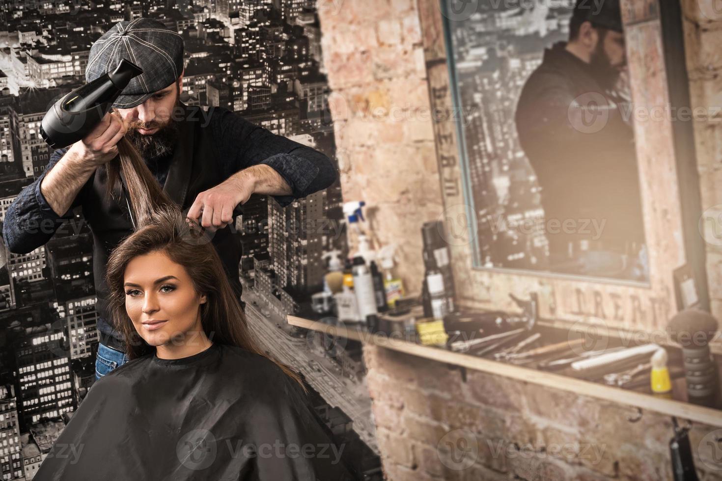 friseur während der arbeit mit schöner klientin im salon foto