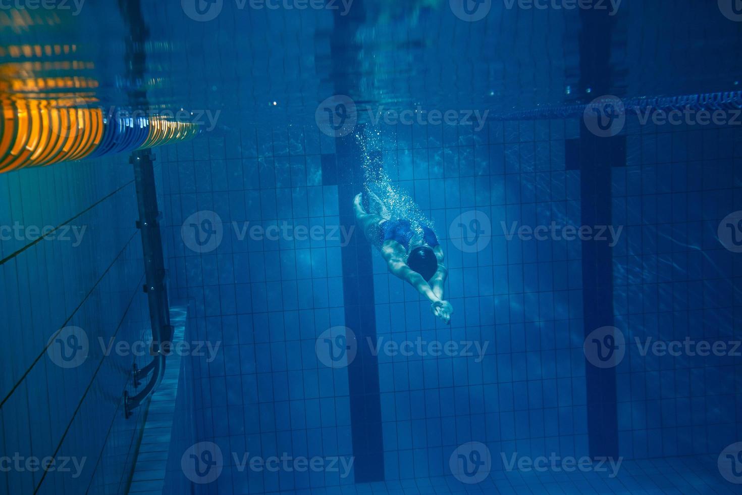 Schwimmerin unter Wasser während ihres Trainings im Pool foto