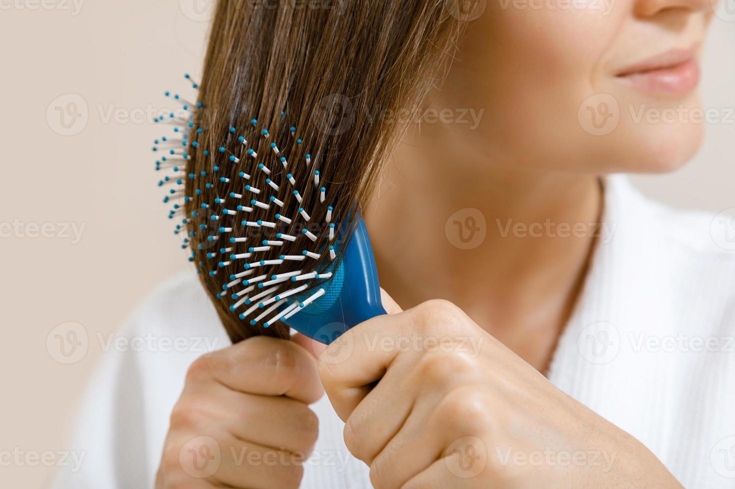 Nahaufnahme des weiblichen Haares mit Haarbürste foto