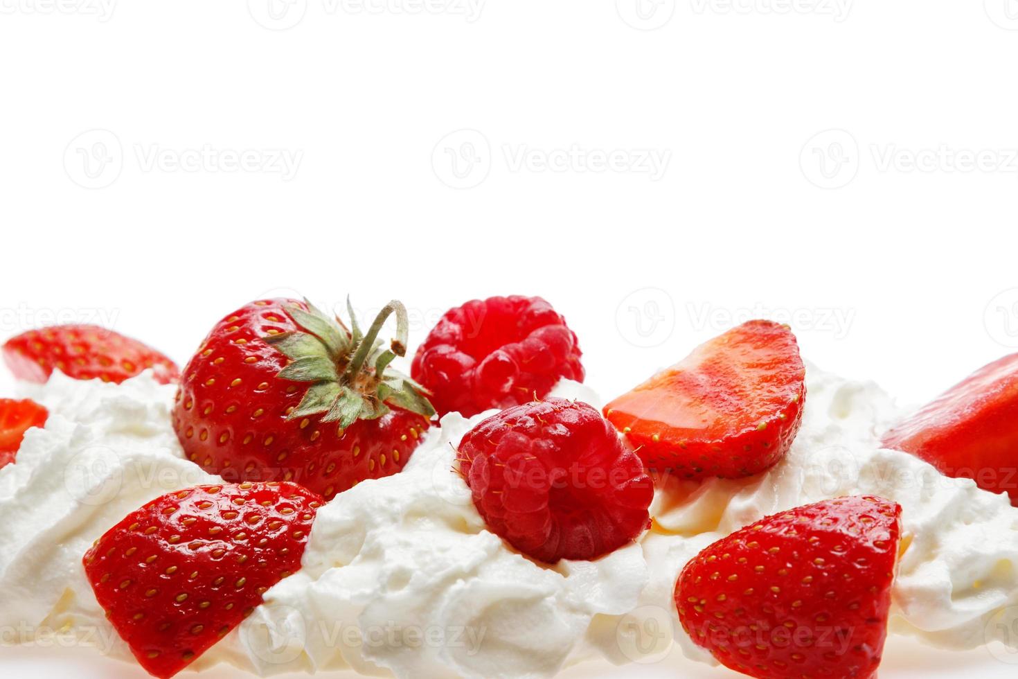 Schlagsahne und süße Beeren auf weißem Hintergrund foto
