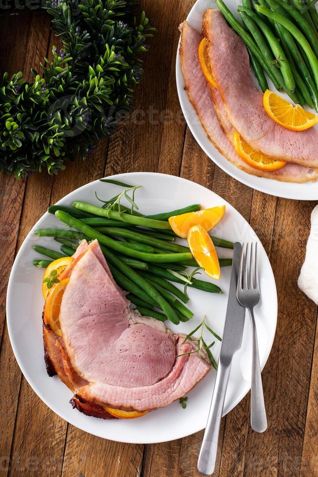 weihnachts- oder erntedankspiralschnittener schinken mit orangen und kräutern foto